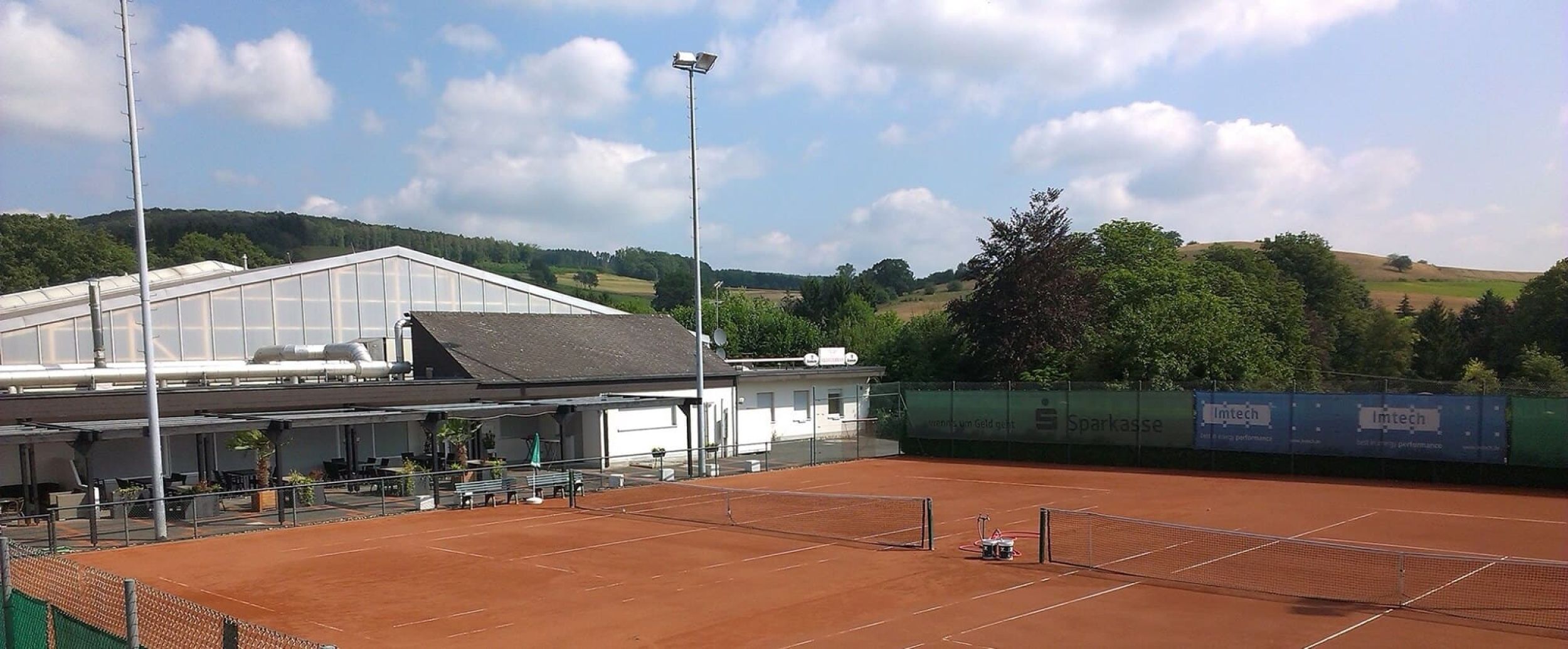 Tennishalle innen im Dunkeln mit einem erleuchteten Platz